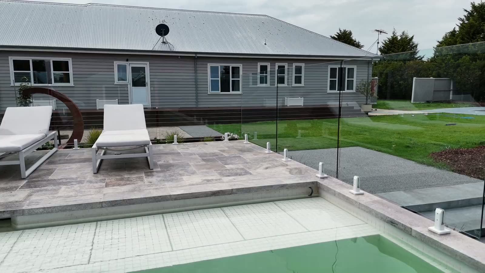 Frameless glass pool fence installed around a backyard swimming pool in Regional Victoria
