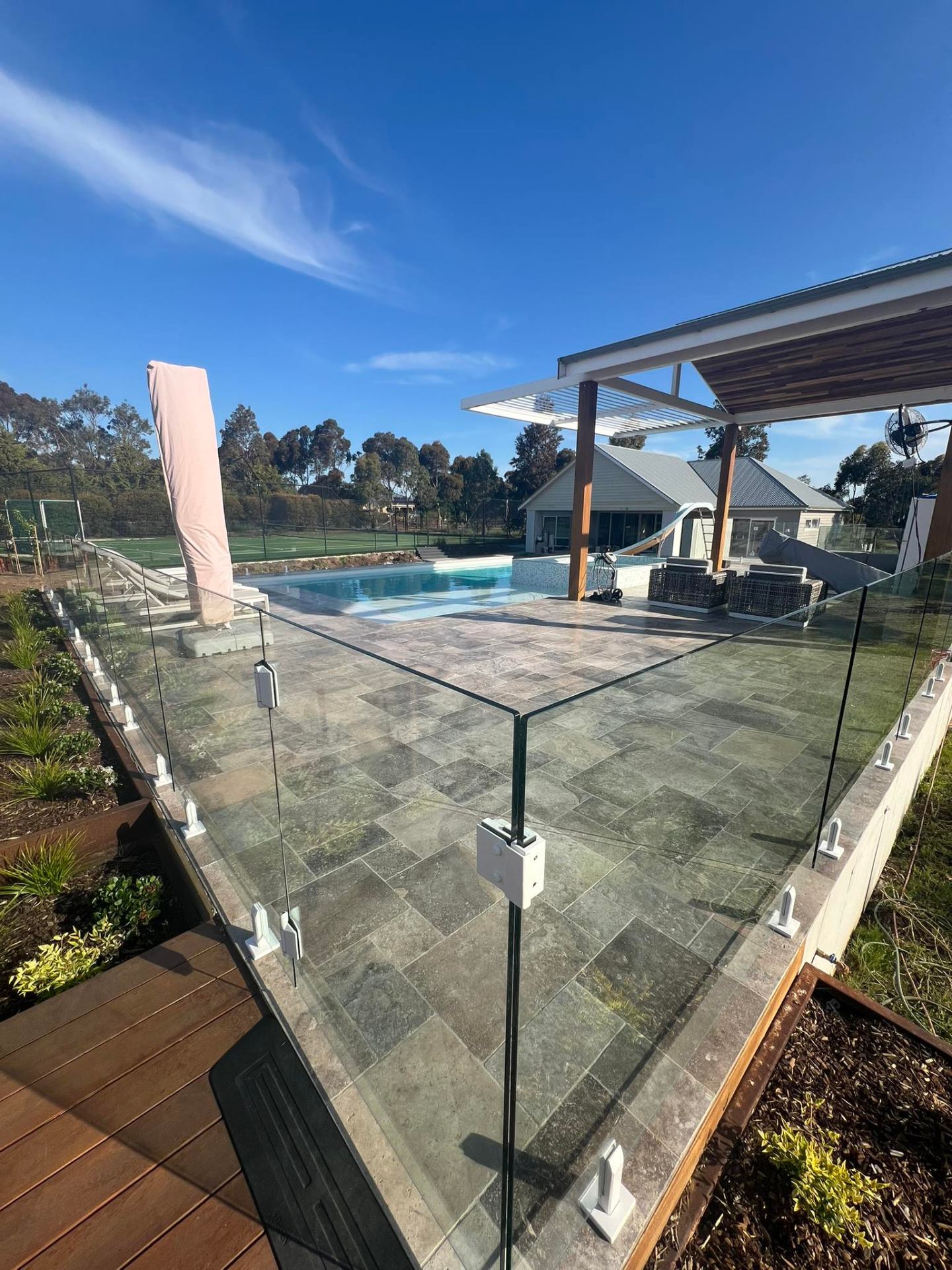Frameless glass pool fence installed around a backyard swimming pool in Regional Victoria